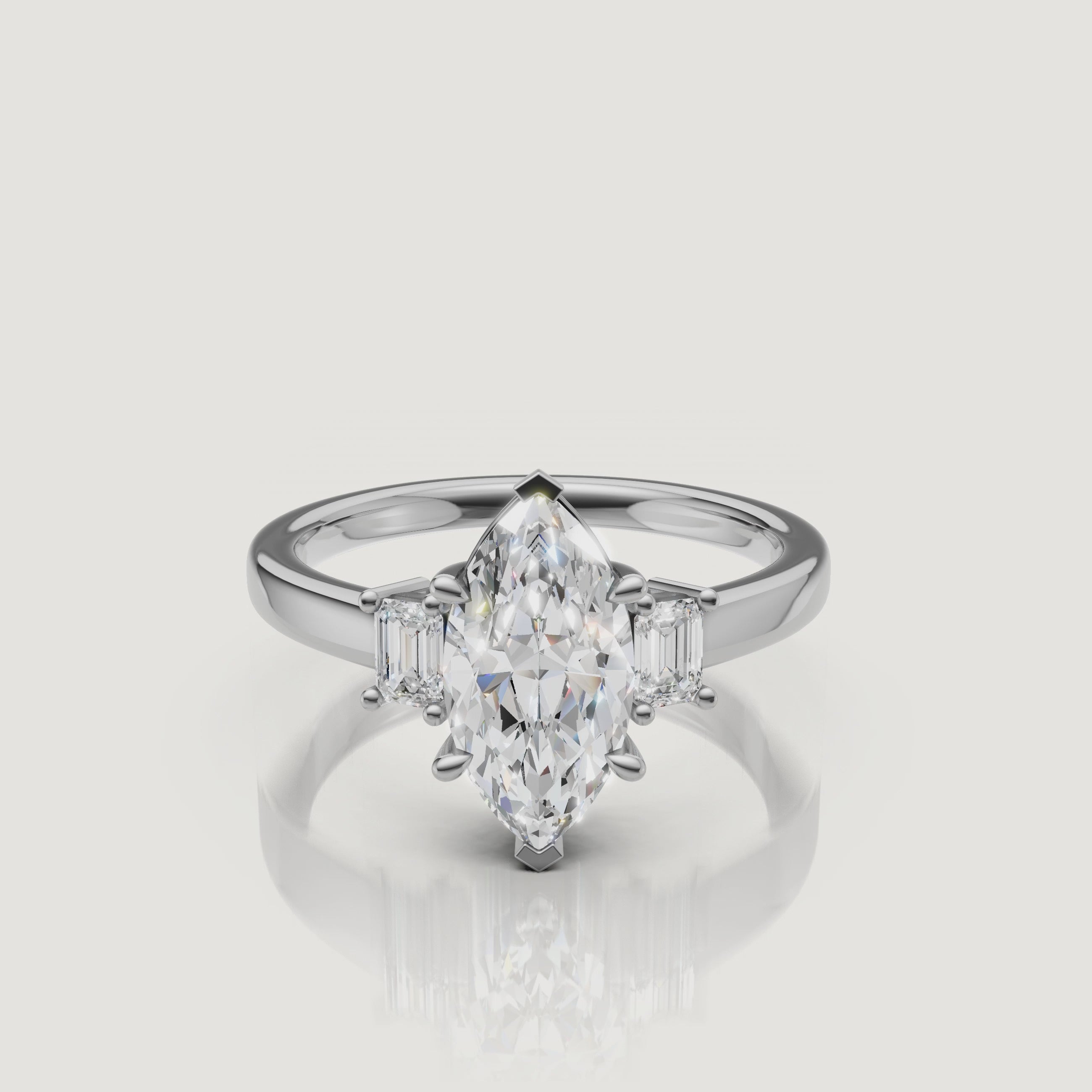 High-definition video of a Rual Diamonds white gold marquise-cut engagement ring, highlighting the crisp fire of the elongated center stone and the diamond-encrusted three-stone setting