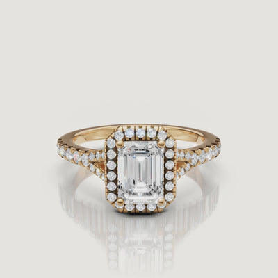 A cinematic 360-degree view of an emerald cut diamond halo ring in 18k yellow gold by Raul Diamonds, showcasing the step-cut facets and shimmering split shank