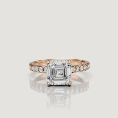 Cinematic close-up video of a rose gold Asscher cut diamond ring, highlighting the warm metal tones and the light-reflecting facets of the center stone