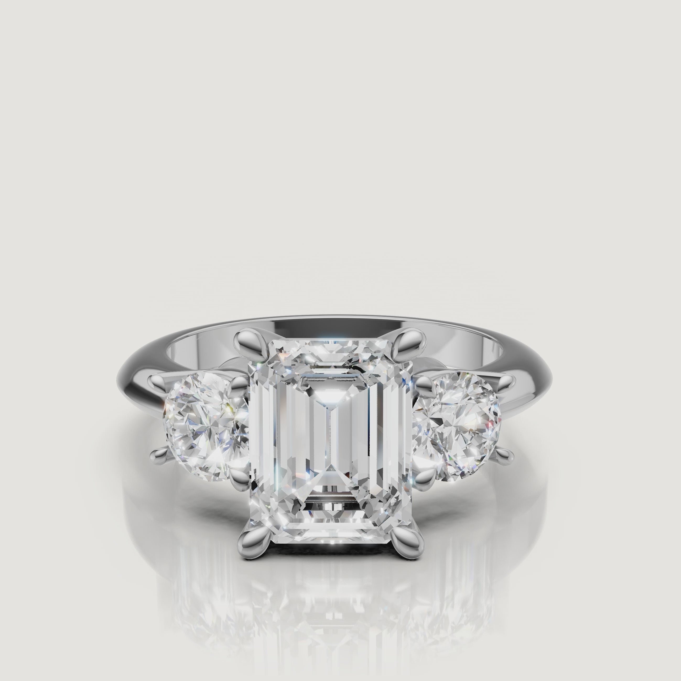 High-definition video of the Raul Diamonds white gold emerald cut three-stone engagement ring, demonstrating the elegant contrast between emerald and round diamond cuts.