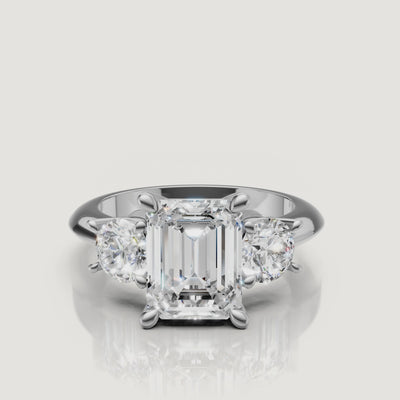 High-definition video of the Raul Diamonds white gold emerald cut three-stone engagement ring, demonstrating the elegant contrast between emerald and round diamond cuts.