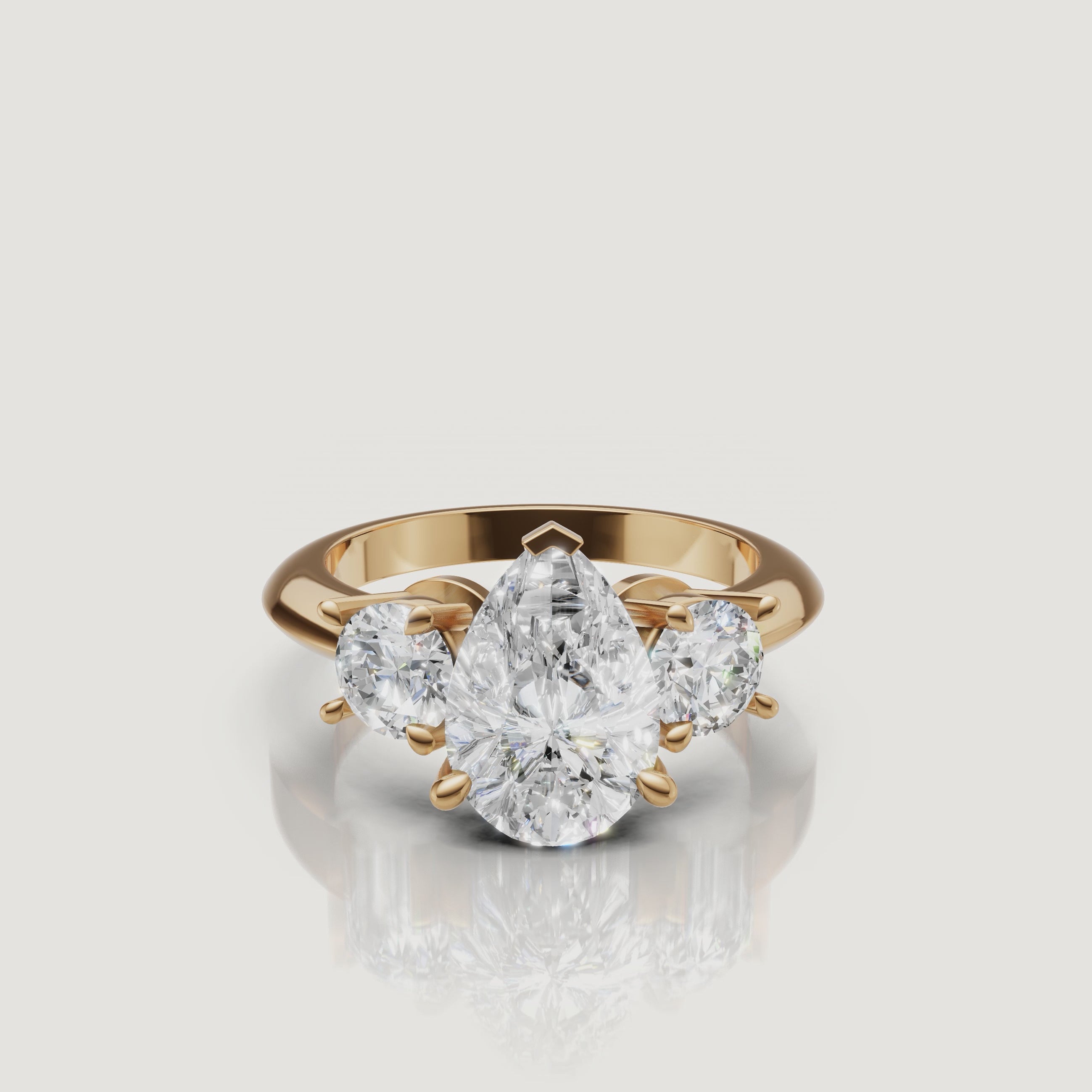 360-degree video showcase of the Raul Diamonds pear cut three-stone ring in yellow gold, highlighting the elegant teardrop shape and the fire of the round side diamonds.