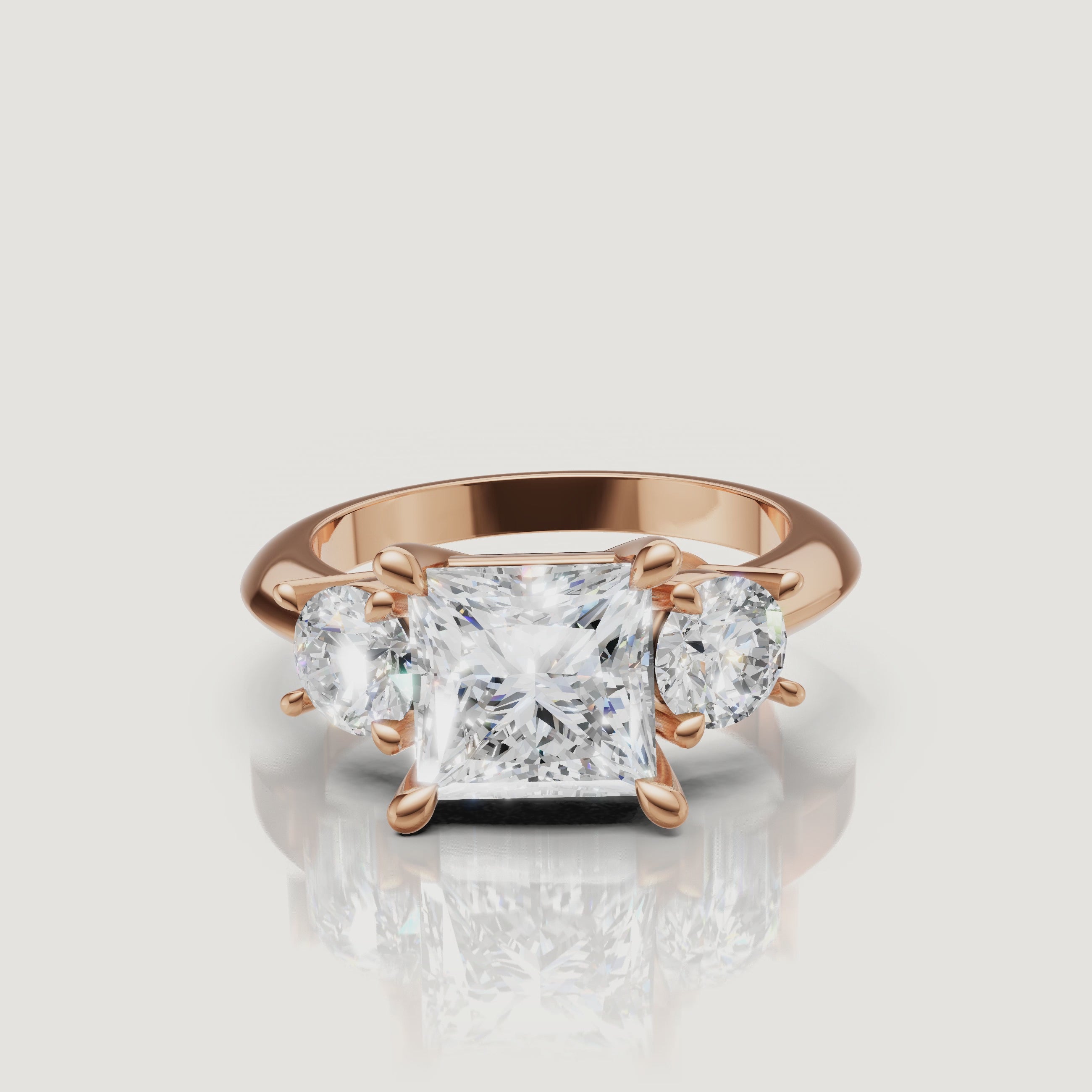 Cinematic close-up of the Victoria rose gold princess trilogy ring, focusing on the warm blush metal and the exceptional light return of the square-cut center diamond.