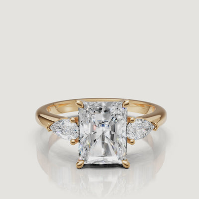 video of radiant cut lab grown diamond engagement ring with pear side stones in 14k yellow gold