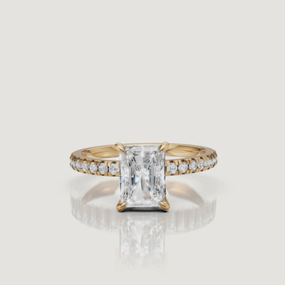 "Cinematic 360-degree video of a Raul Diamonds yellow gold radiant-cut ring, showing the brilliant light performance and the detailed hidden halo craftsmanship."