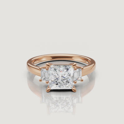 HD video featuring the rose gold princess cut three-stone diamond ring by Raul Diamonds, focusing on the warm metal tones and the clear reflection of the side baguette diamonds.