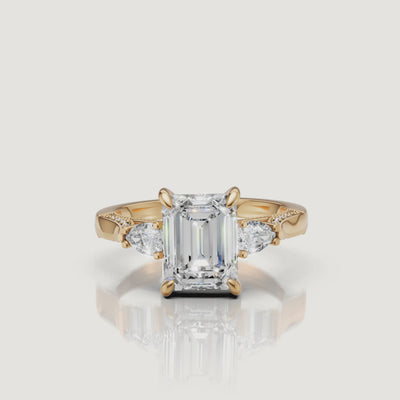 Lustrous 18K Yellow Gold Emerald Cut Diamond Ring with Pear Side Stones - 360 View | Raul Diamonds