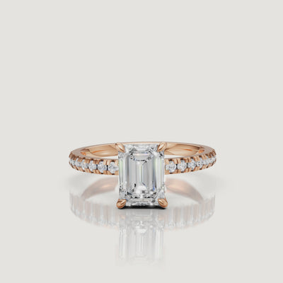 Close-up cinematic video of a romantic rose gold emerald cut diamond ring, showing the 'hall of mirrors' effect of the center stone and the brilliance of the pavé diamond accents