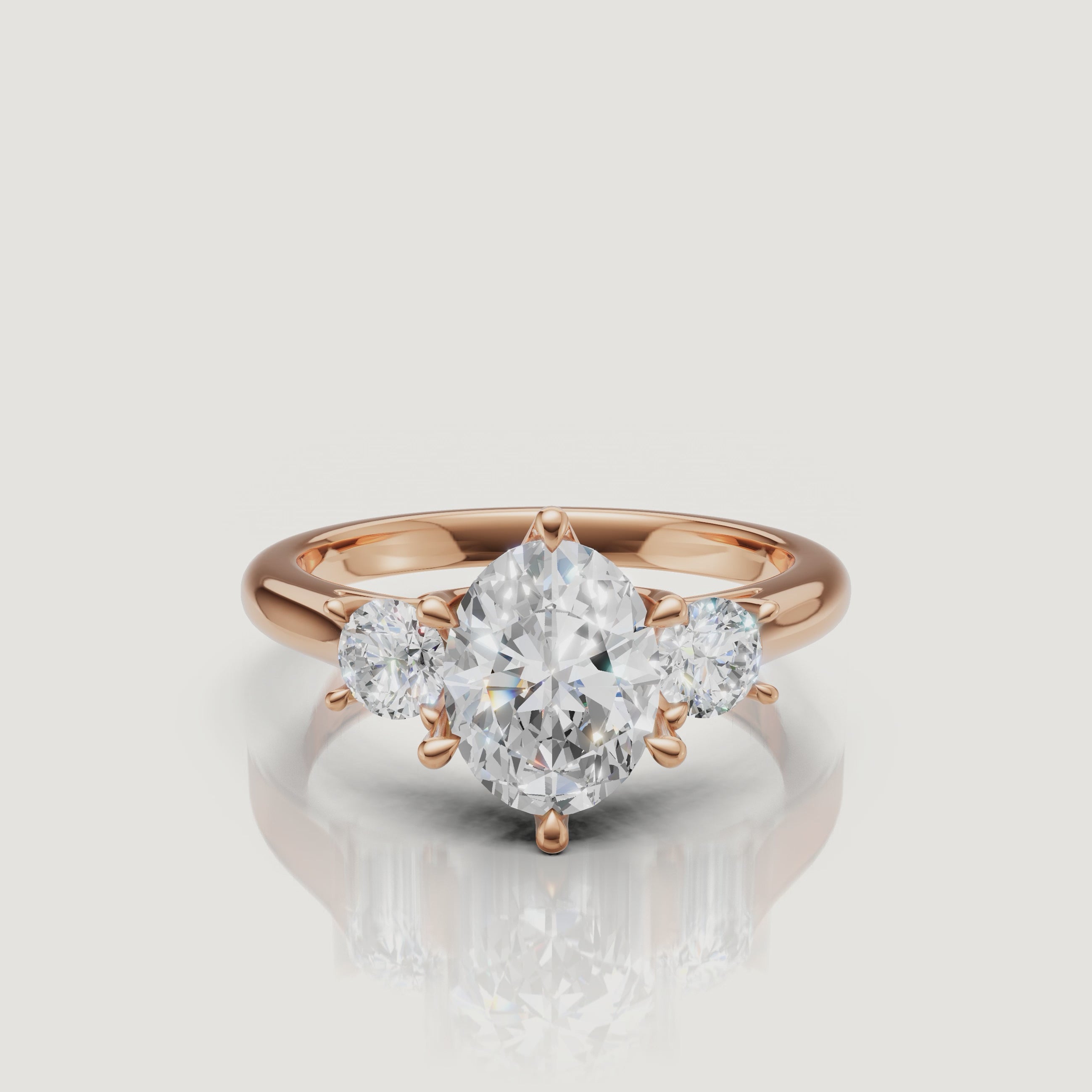 Cinematic close-up of the Isabella rose gold oval trilogy ring, focusing on the warm blush metal and the seamless transition between the oval and pear-shaped stones.