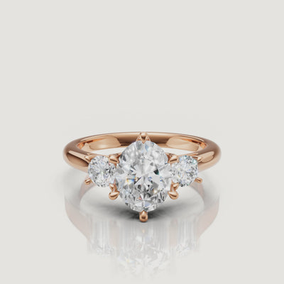Cinematic close-up of the Isabella rose gold oval trilogy ring, focusing on the warm blush metal and the seamless transition between the oval and pear-shaped stones.
