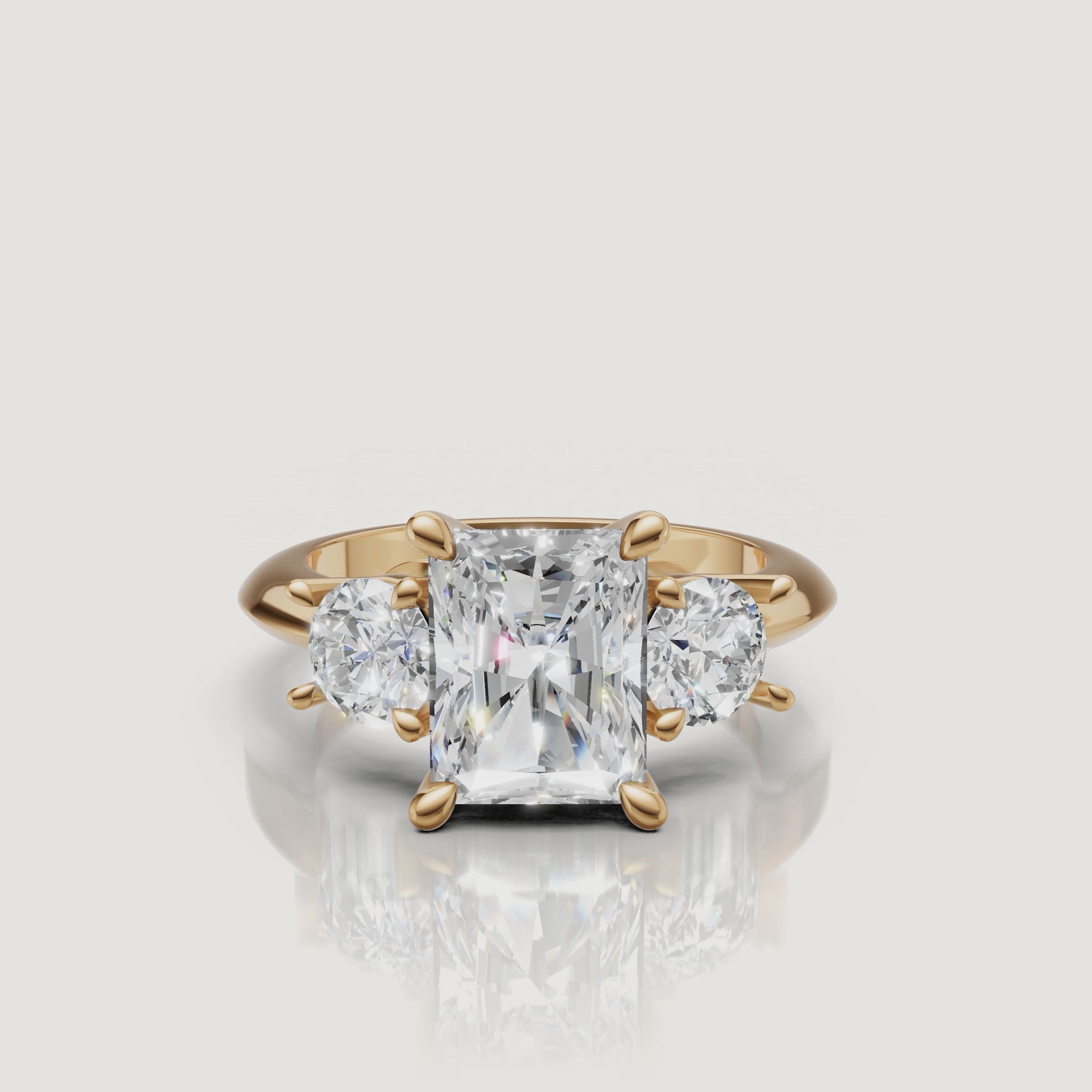 360-degree video showcase of the Raul Diamonds radiant cut three-stone ring in yellow gold, highlighting the "crushed ice" brilliance of the center stone and round side diamonds.