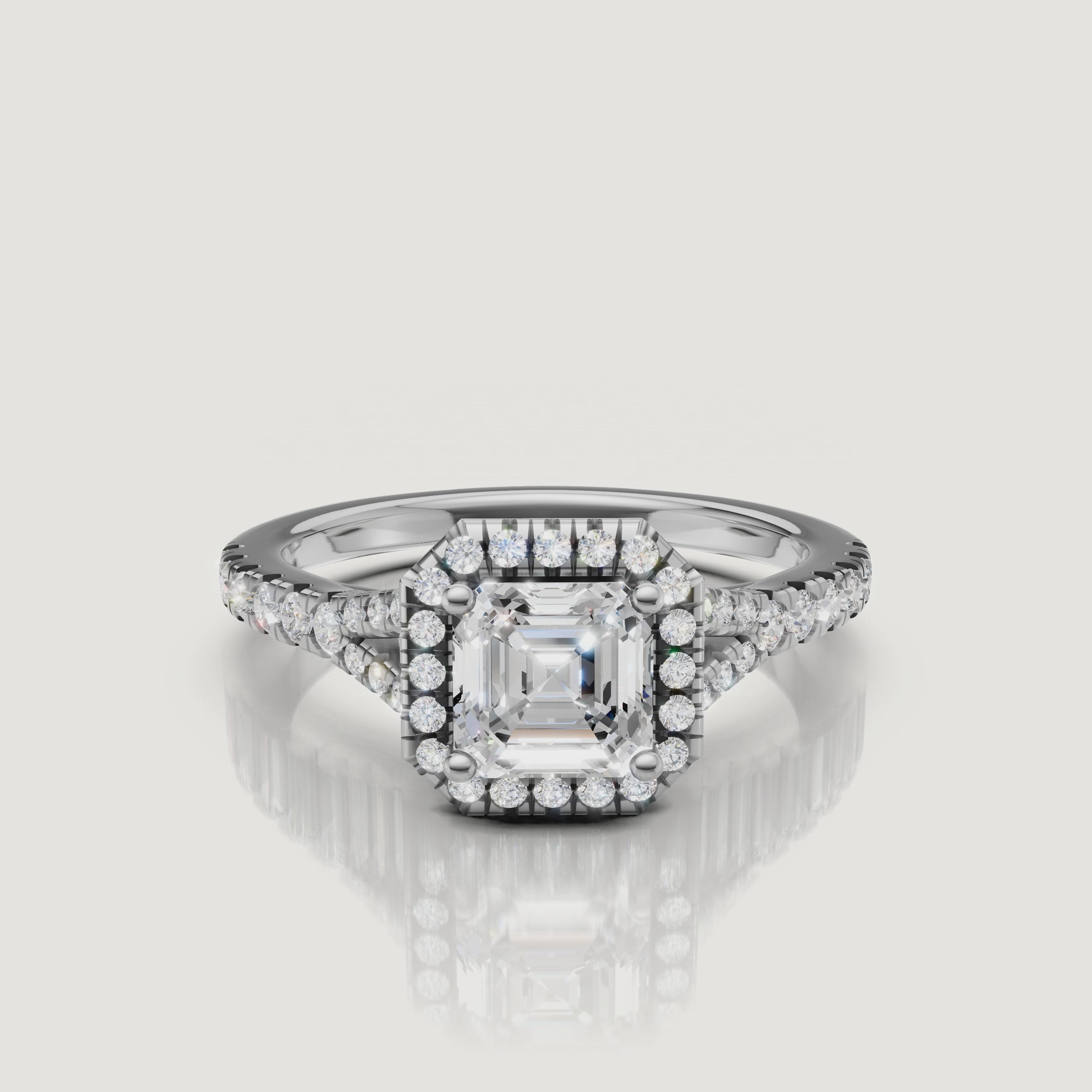 High-definition video of a white gold Asscher cut diamond ring with a pavé halo and split shank, showcasing the clarity and fire of the center stone