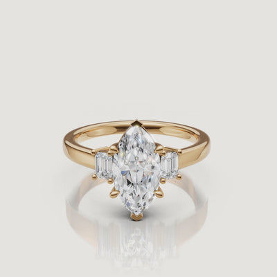 A high-definition 360-degree rotation of a Rual Diamonds marquise-cut three-stone ring in 14k yellow gold, showcasing the elegant teardrop-like points and shimmering pavé shank