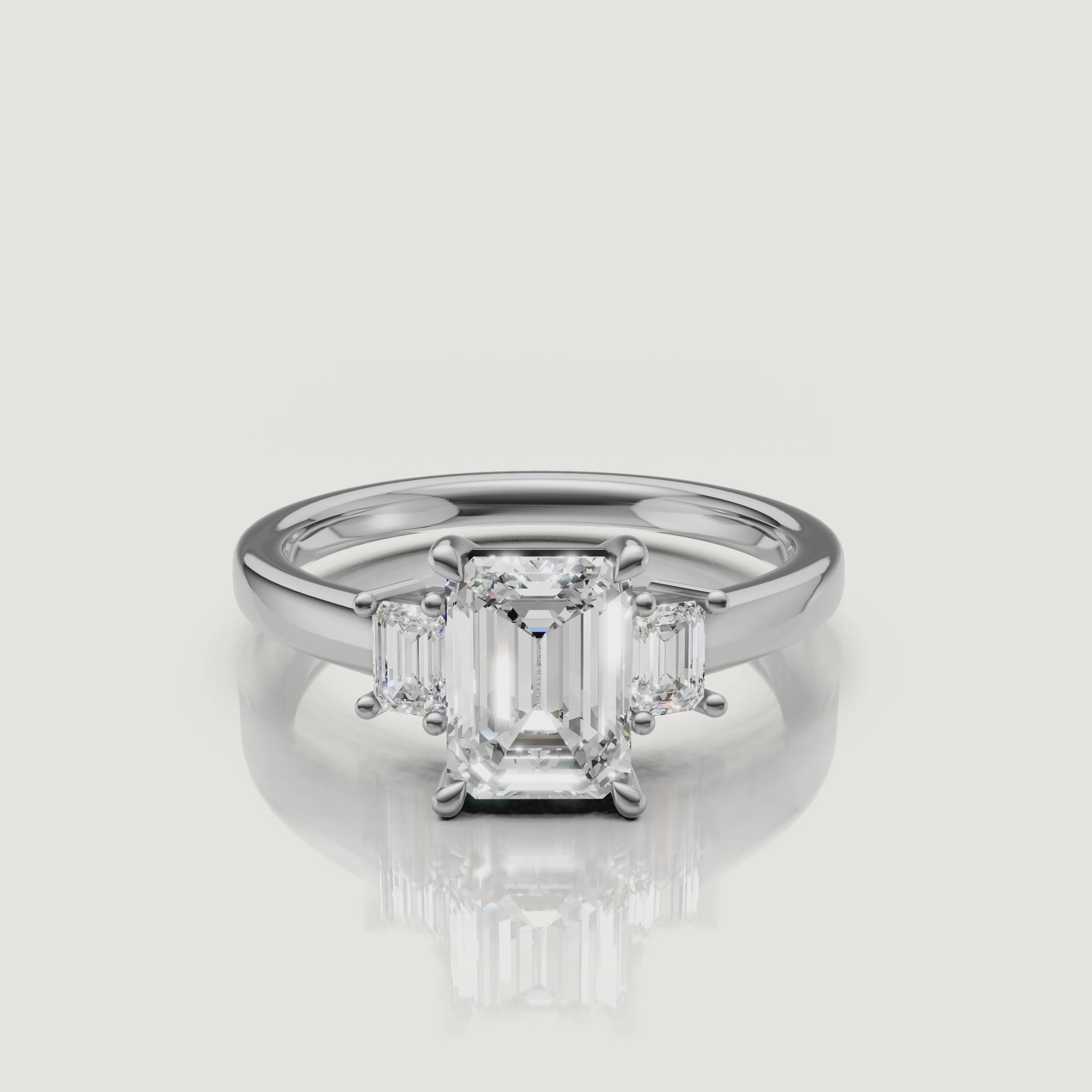 High-definition video of a Rual Diamonds white gold double emerald cut engagement ring, highlighting the distinct 'hall of mirrors' light effect of the parallel diamonds and the shimmering pavé bridge bridge