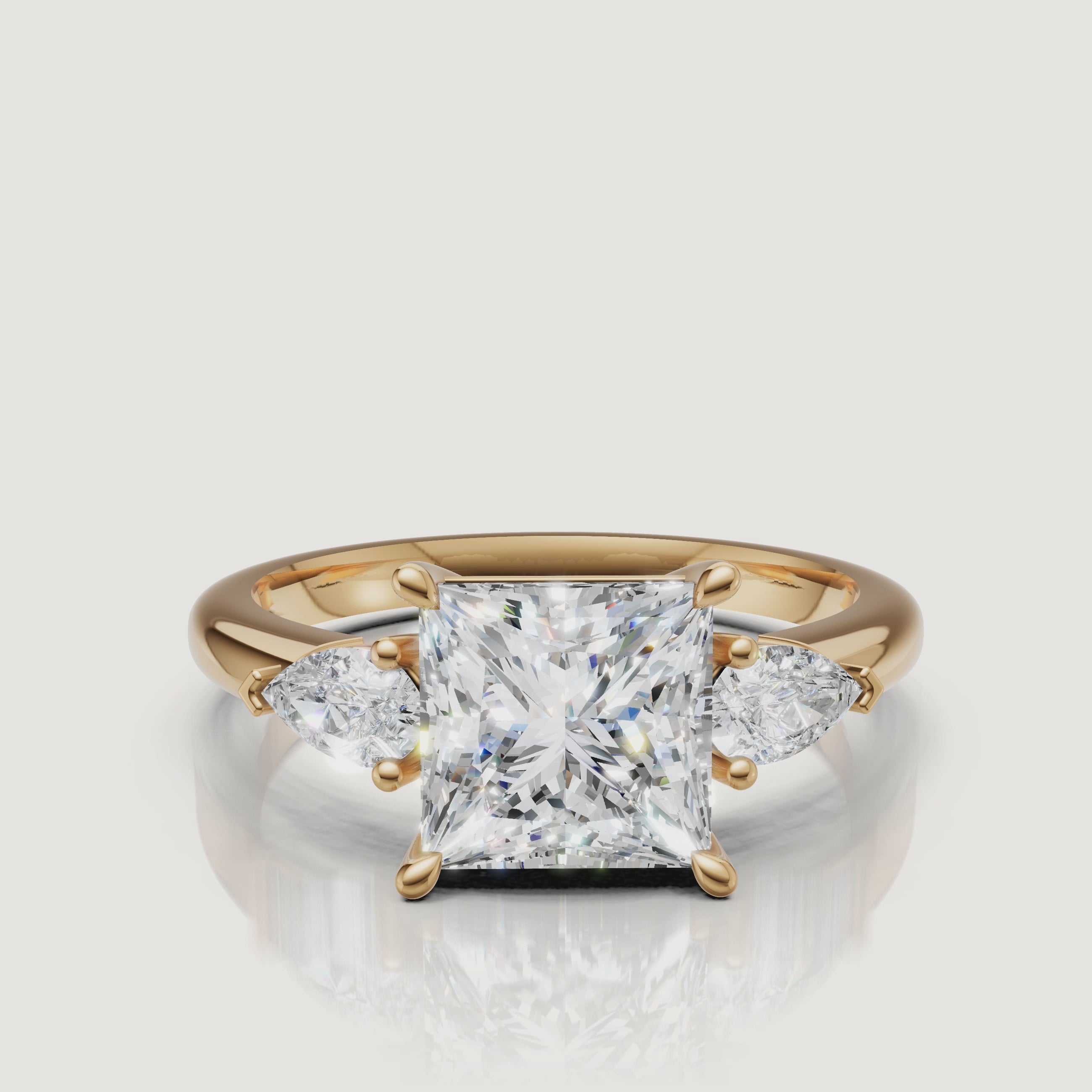 video of princess cut lab grown diamond engagement ring with pear side stones in 14k yellow gold