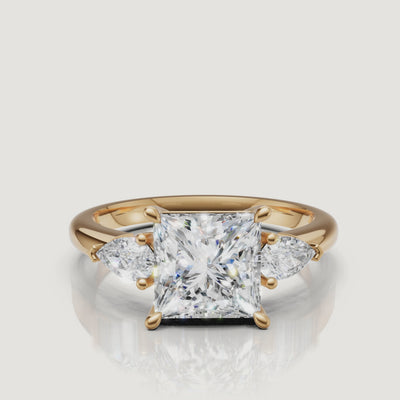 video of princess cut lab grown diamond engagement ring with pear side stones in 14k yellow gold