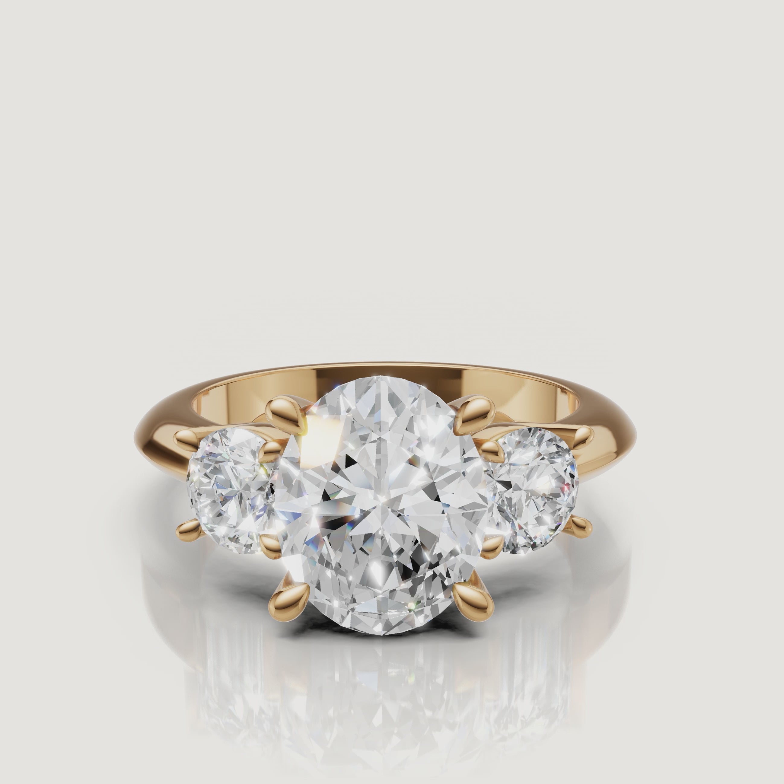 360-degree video showcase of the Raul Diamonds oval cut three-stone ring in yellow gold, highlighting the brilliant fire of the oval center and round side diamonds.