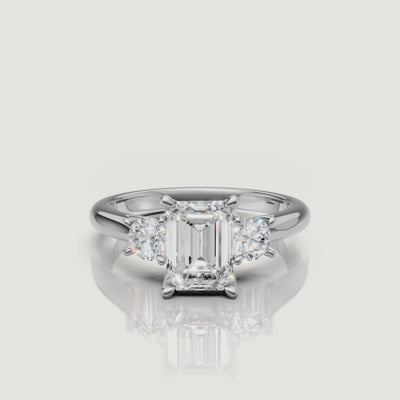 High-definition video of the Raul Diamonds white gold emerald cut three-stone engagement ring, demonstrating the brilliant contrast between the emerald and round diamond cuts.