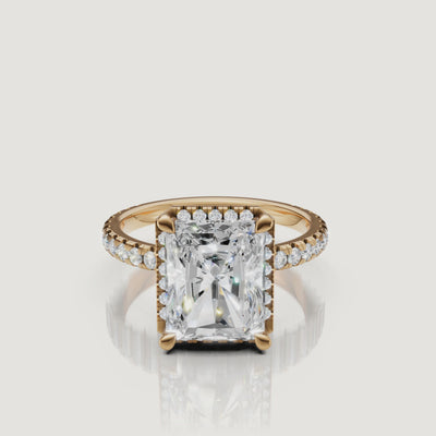 Cinematic 360-degree rotation of a Raul Diamonds Radiant Cut Hidden Halo ring in 18k yellow gold with a shimmering pavé diamond shank