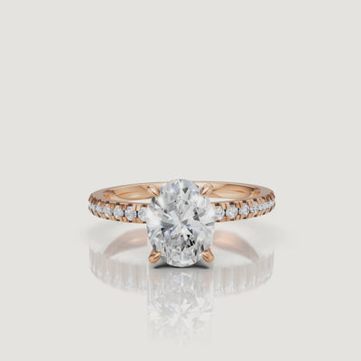 Cinematic video of a rose gold oval-cut diamond ring, rotating to show the blush-toned metal and the shimmering hidden halo design.