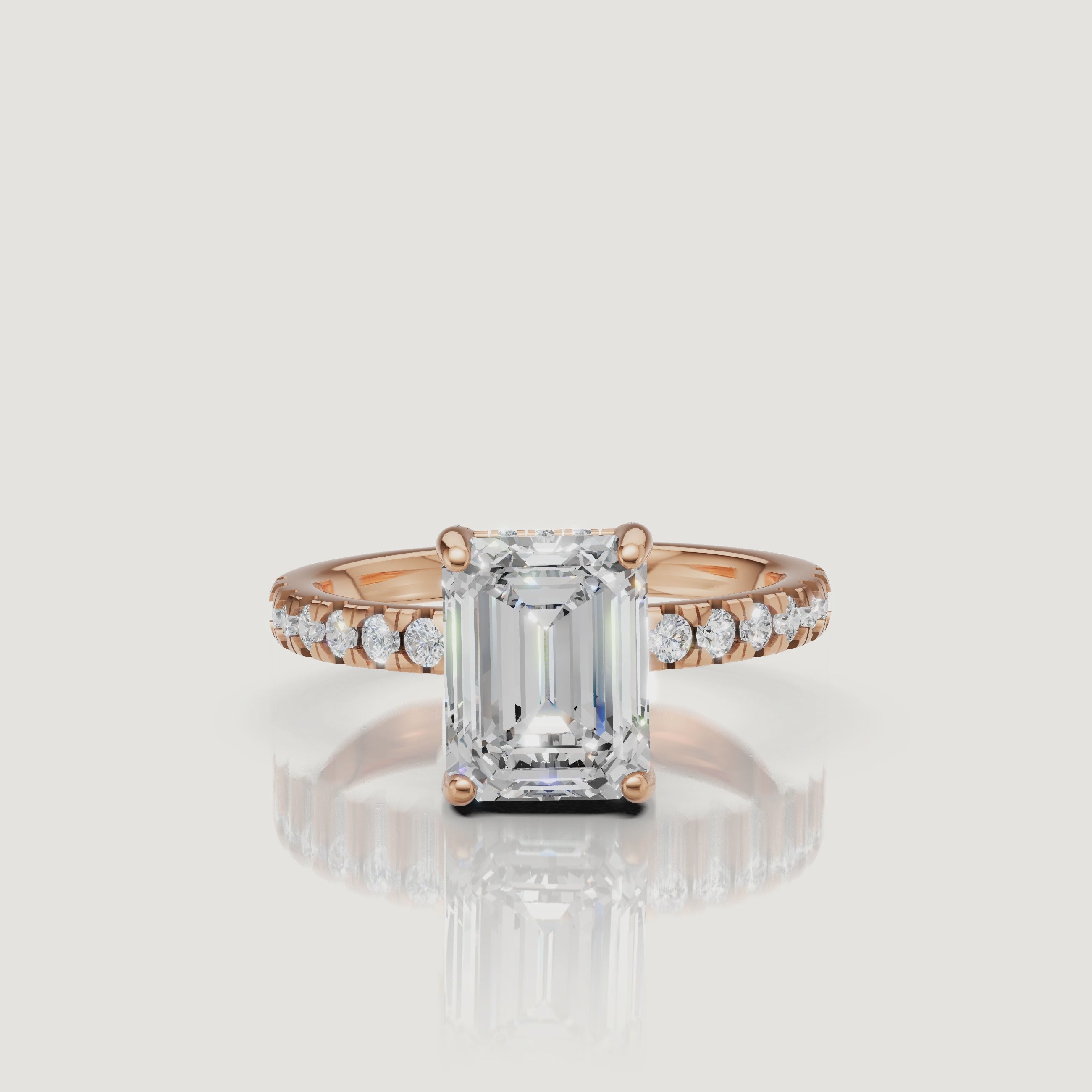 360-degree view of a rose gold emerald-cut diamond ring, highlighting the contrast between the warm metal and the clear, elongated diamond shape