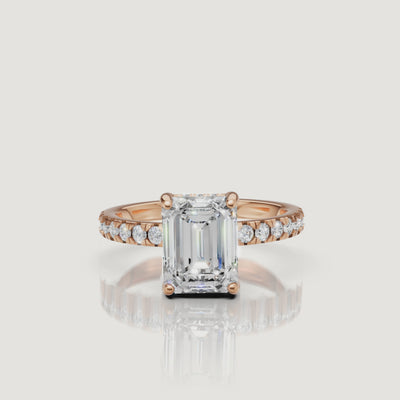 360-degree view of a rose gold emerald-cut diamond ring, highlighting the contrast between the warm metal and the clear, elongated diamond shape