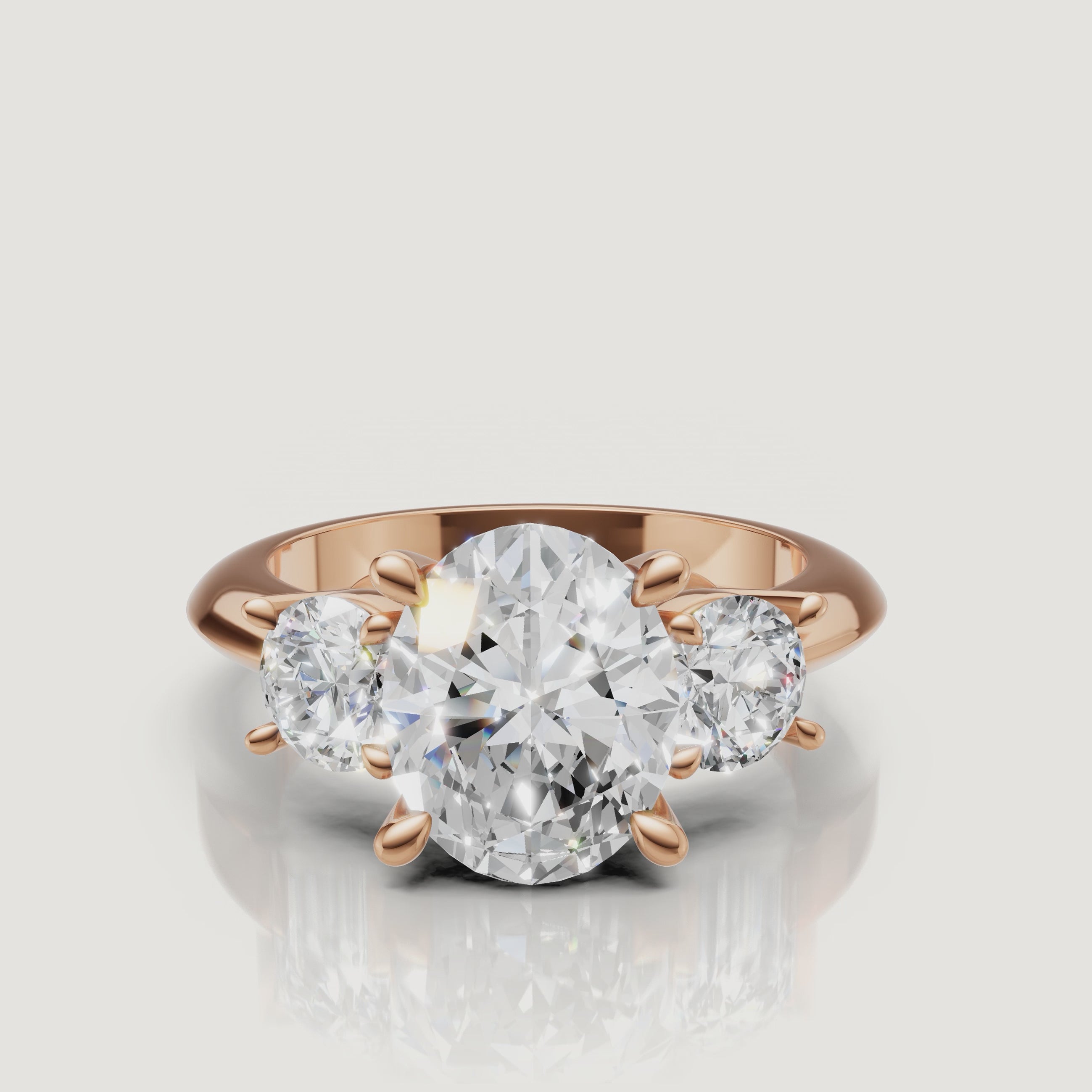 Cinematic close-up of the Seraphina rose gold oval trilogy ring, focusing on the warm blush metal and the exceptional light performance of the oval-shaped center stone.