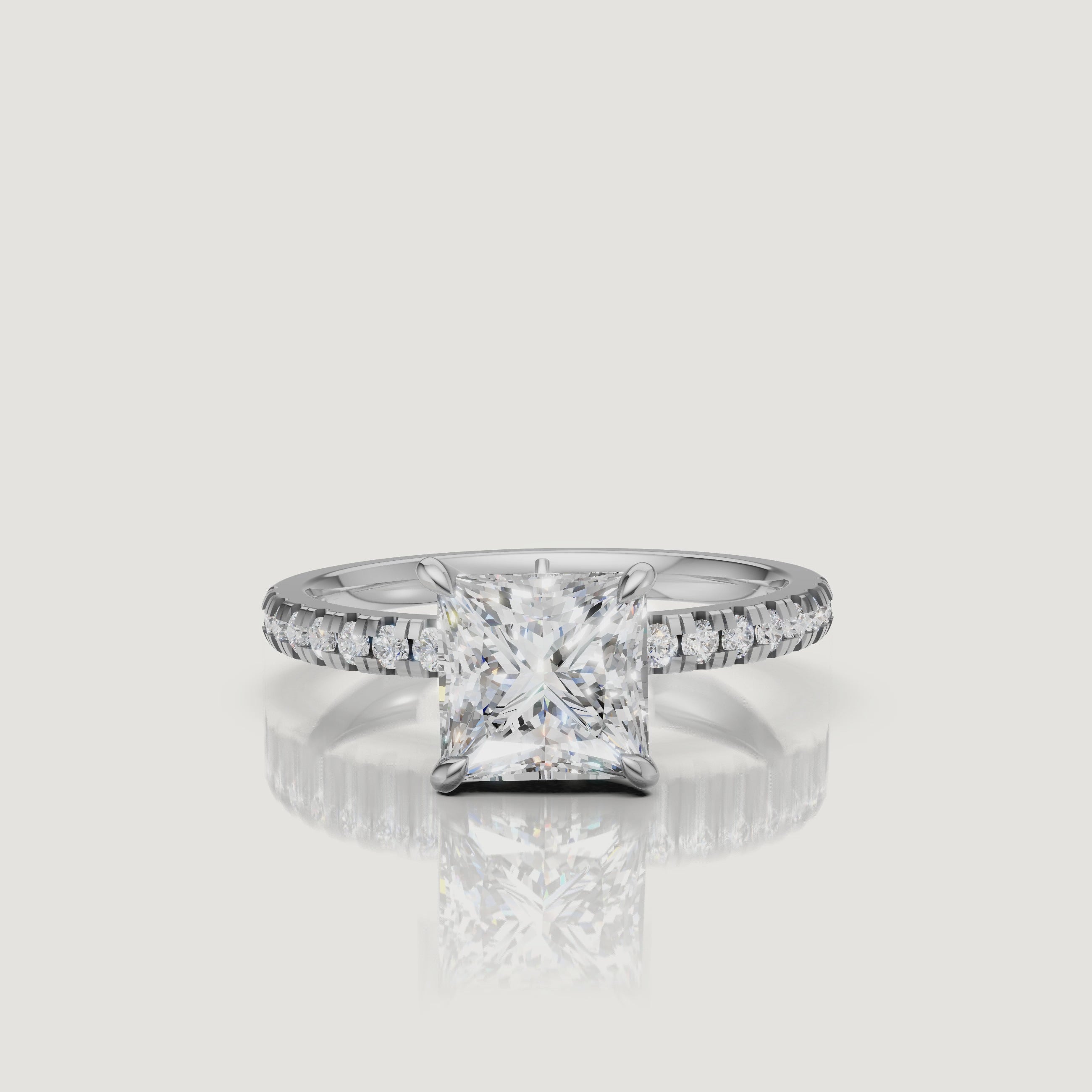 Luxury video of a white gold princess-cut diamond ring, emphasizing the icy brilliance of the center stone and the continuous sparkle of the pavé diamond accents.