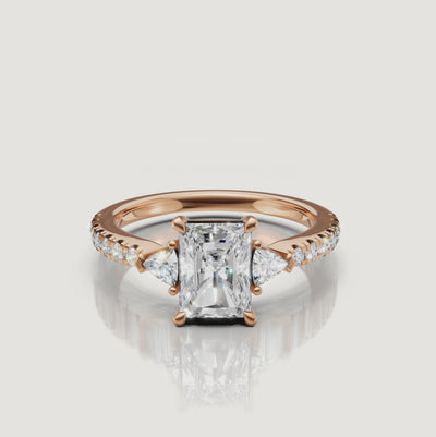 Cinematic close-up of a Rual Diamonds rose gold radiant-cut diamond ring, capturing the warm tones and exceptional sparkle of the three-stone design in motion