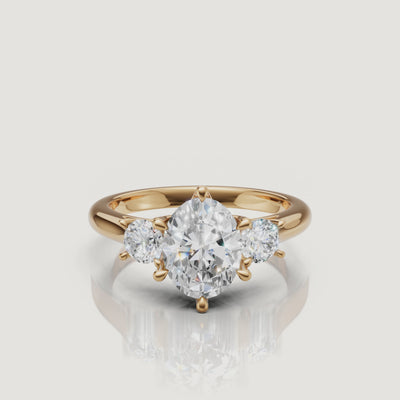 360-degree video showcase of the Raul Diamonds oval cut three-stone ring in yellow gold, highlighting the brilliance of the oval center and pear side diamonds.