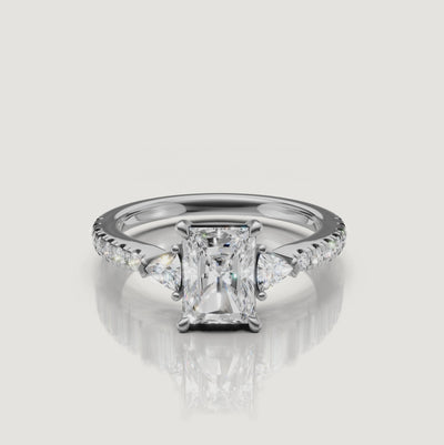 High-definition video of a Rual Diamonds white gold radiant-cut engagement ring, highlighting the crisp 'crushed ice' brilliance of the center stone and diamond-encrusted band