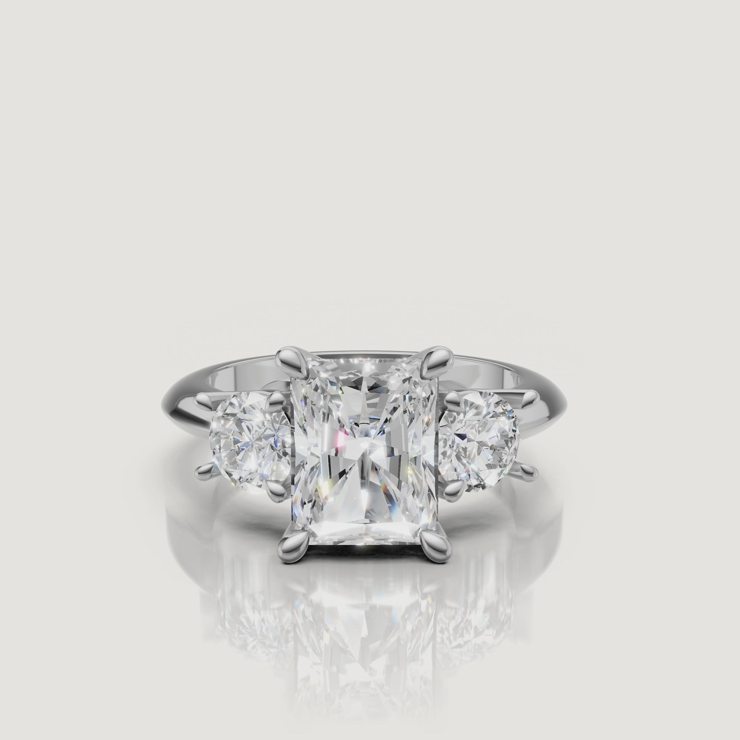 High-definition video of the Raul Diamonds white gold radiant three-stone engagement ring, demonstrating the seamless sparkle and modern elegance of the trilogy setting.