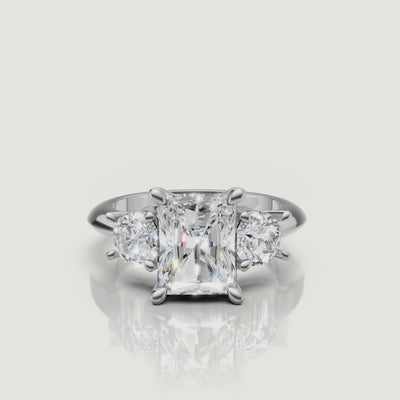 High-definition video of the Raul Diamonds white gold radiant three-stone engagement ring, demonstrating the seamless sparkle and modern elegance of the trilogy setting.