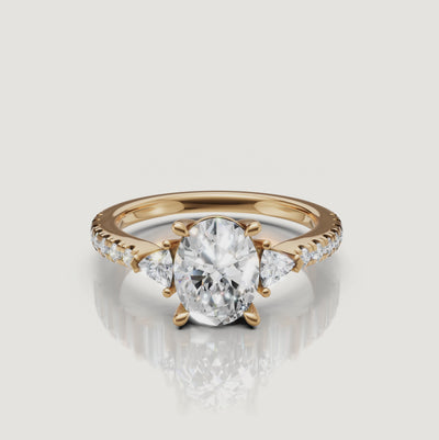 A 360-degree video showcase of a Rual Diamonds oval-cut three-stone ring, highlighting the brilliant center stone and trillion-cut diamond accents