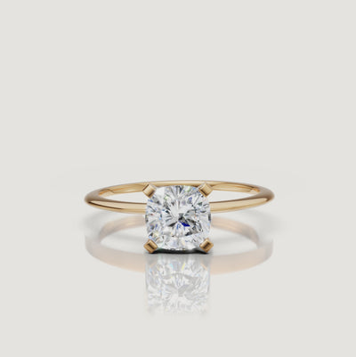 Cinematic video of a cushion cut lab grown diamond solitaire engagement ring in yellow gold by Raul Diamonds featuring elegant hand movement, macro diamond sparkle, warm luxury lighting, and premium bridal jewelry styling