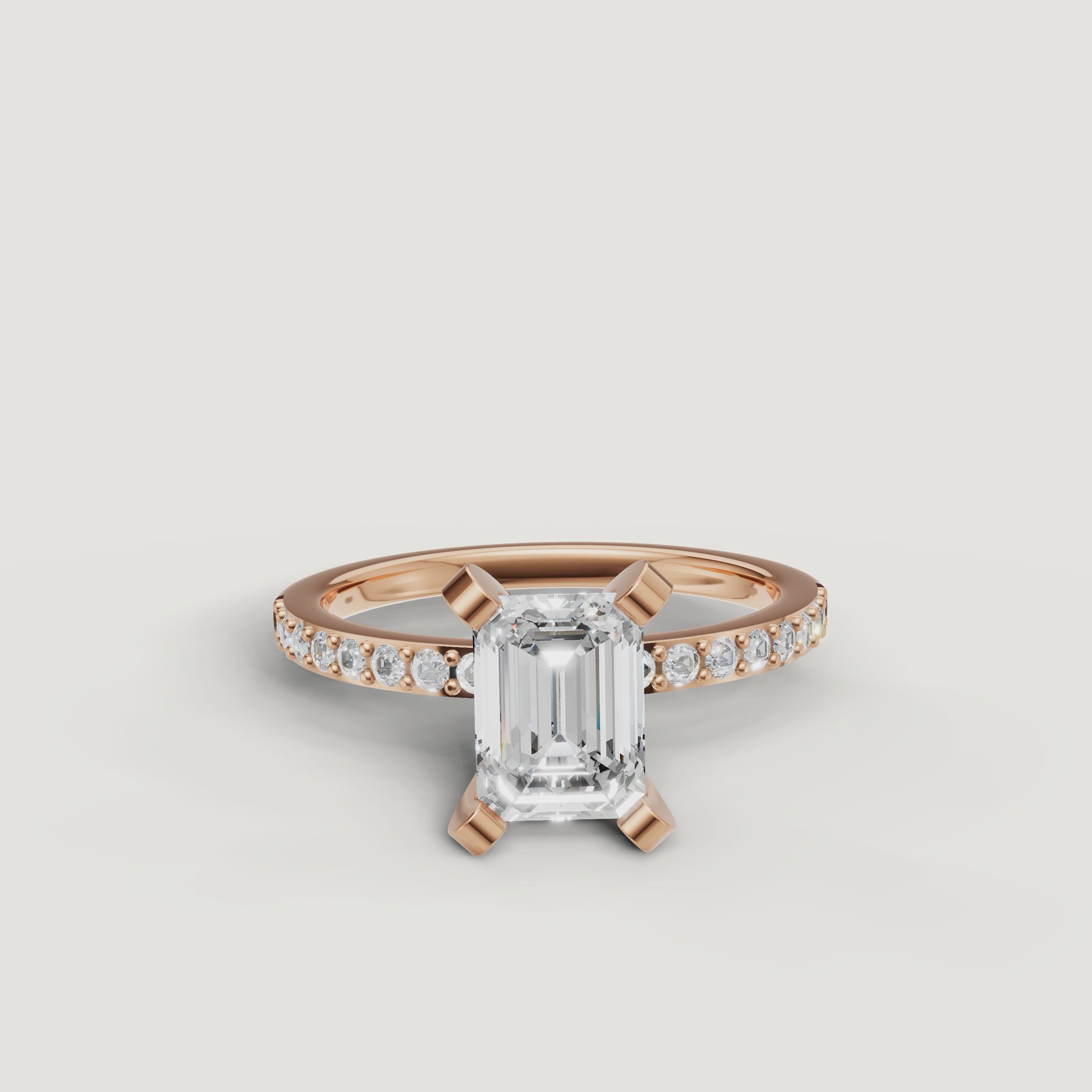 Cinematic close-up of the Celine emerald cut diamond ring in rose gold, highlighting the warm blush metal and high-clarity step-cut facets.