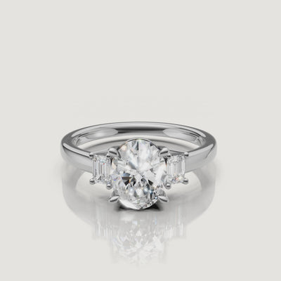 Cinematic product video of a white gold three-stone oval diamond ring, demonstrating the fire and brilliance of the stones as the ring rotates on a white background