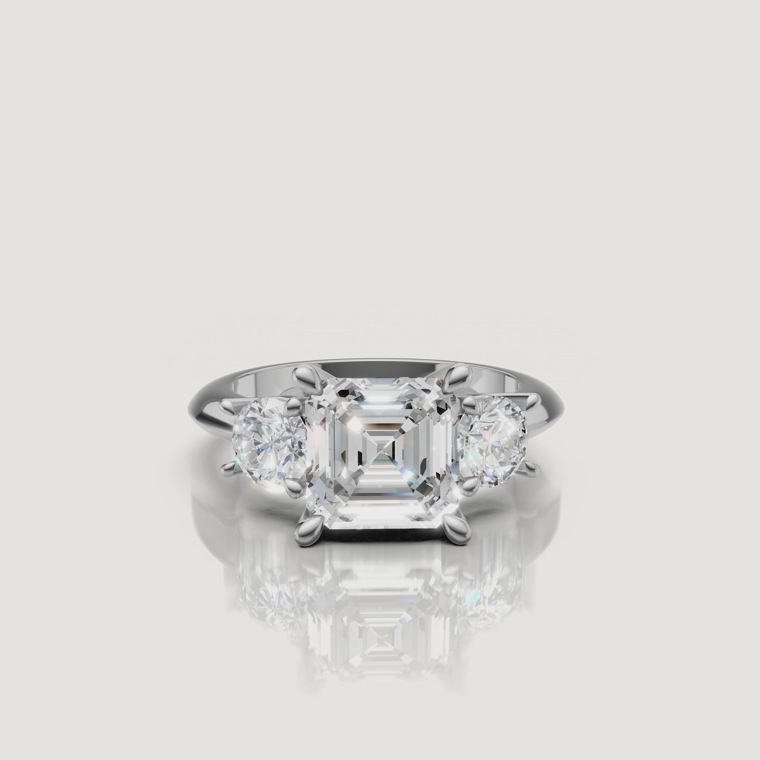 High-definition video of the Raul Diamonds white gold Asscher three-stone engagement ring, demonstrating the brilliant architectural geometric flow of the trilogy setting