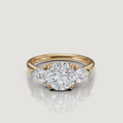 video of round brilliant lab grown diamond engagement ring with trillion side stones in 14k yellow gold