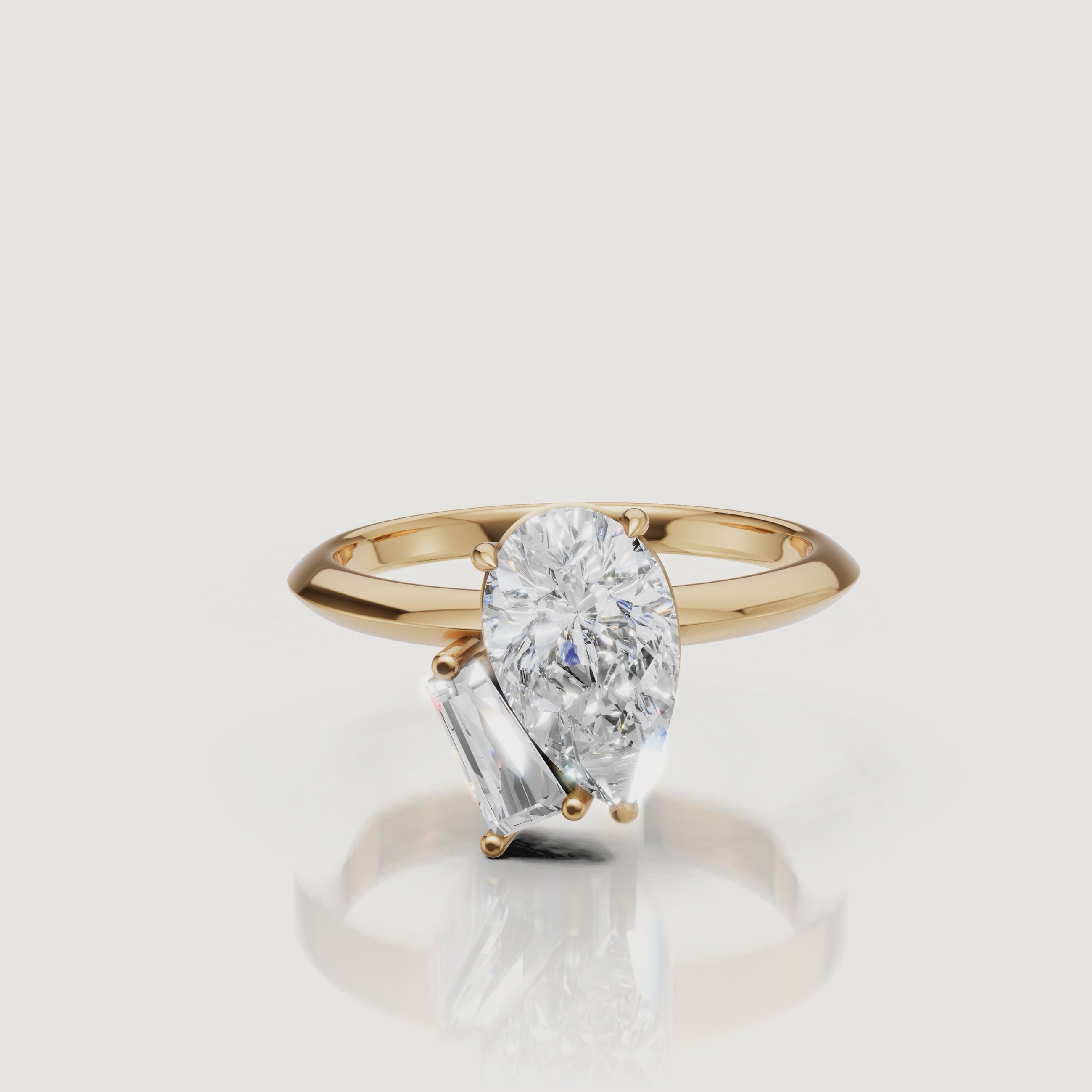 Yellow Gold Video Alt: Rotating video of Raul Diamonds yellow gold toi et moi ring with pear and trapezoid diamonds