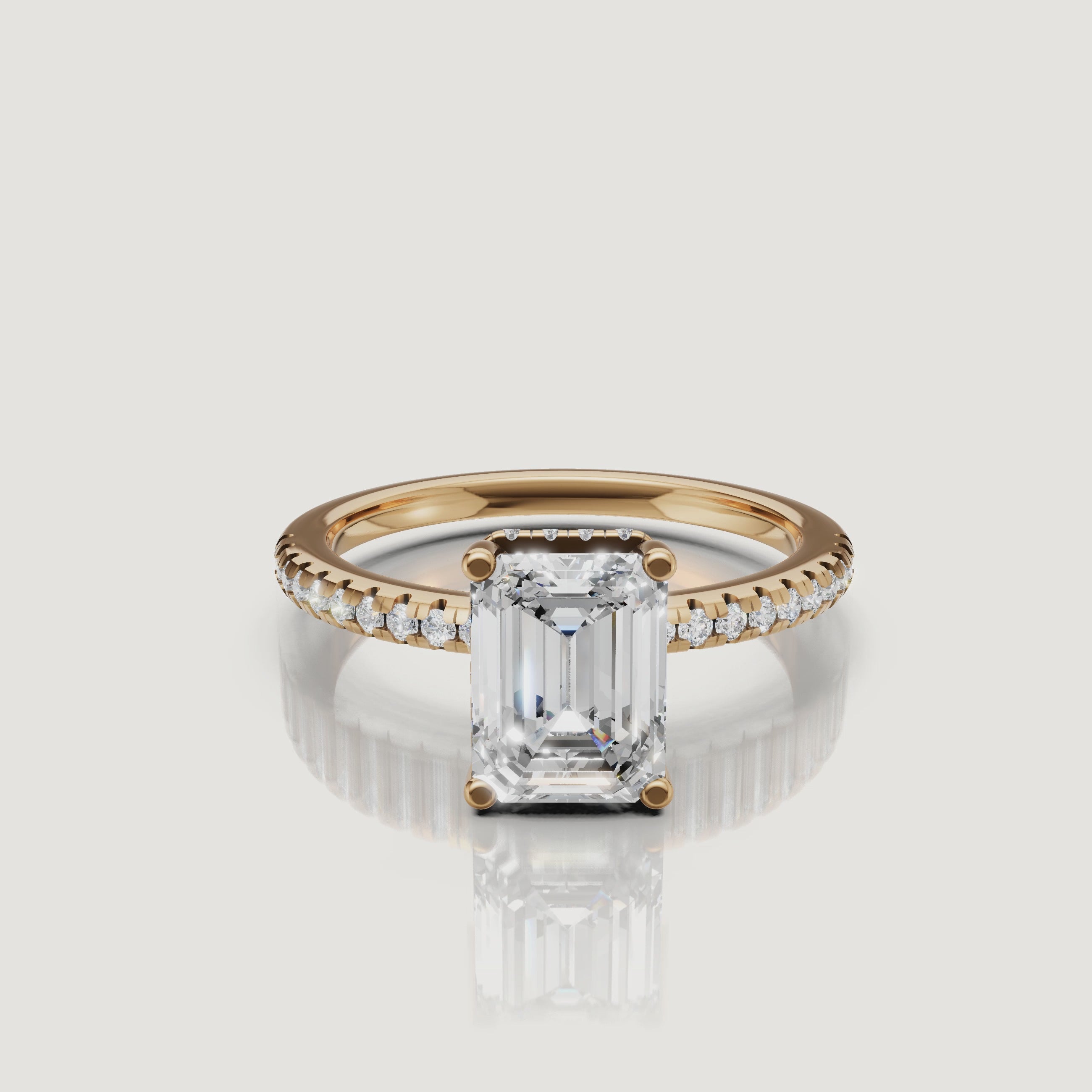 A detailed 4K video of a yellow gold emerald cut diamond ring by Raul Diamonds, rotating to show the hidden halo and brilliant pavé-set diamonds.