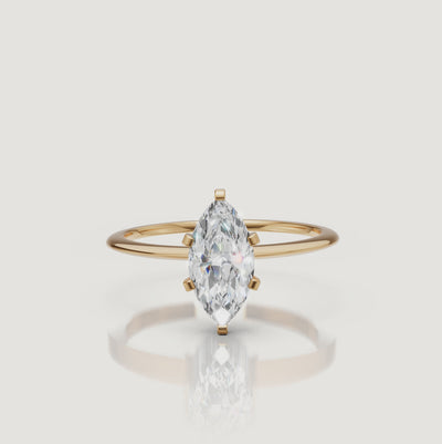 Cinematic video of a marquise cut lab grown diamond solitaire engagement ring in yellow gold by Raul Diamonds featuring elegant hand movement, macro diamond sparkle, warm luxury lighting, and premium bridal jewelry styling