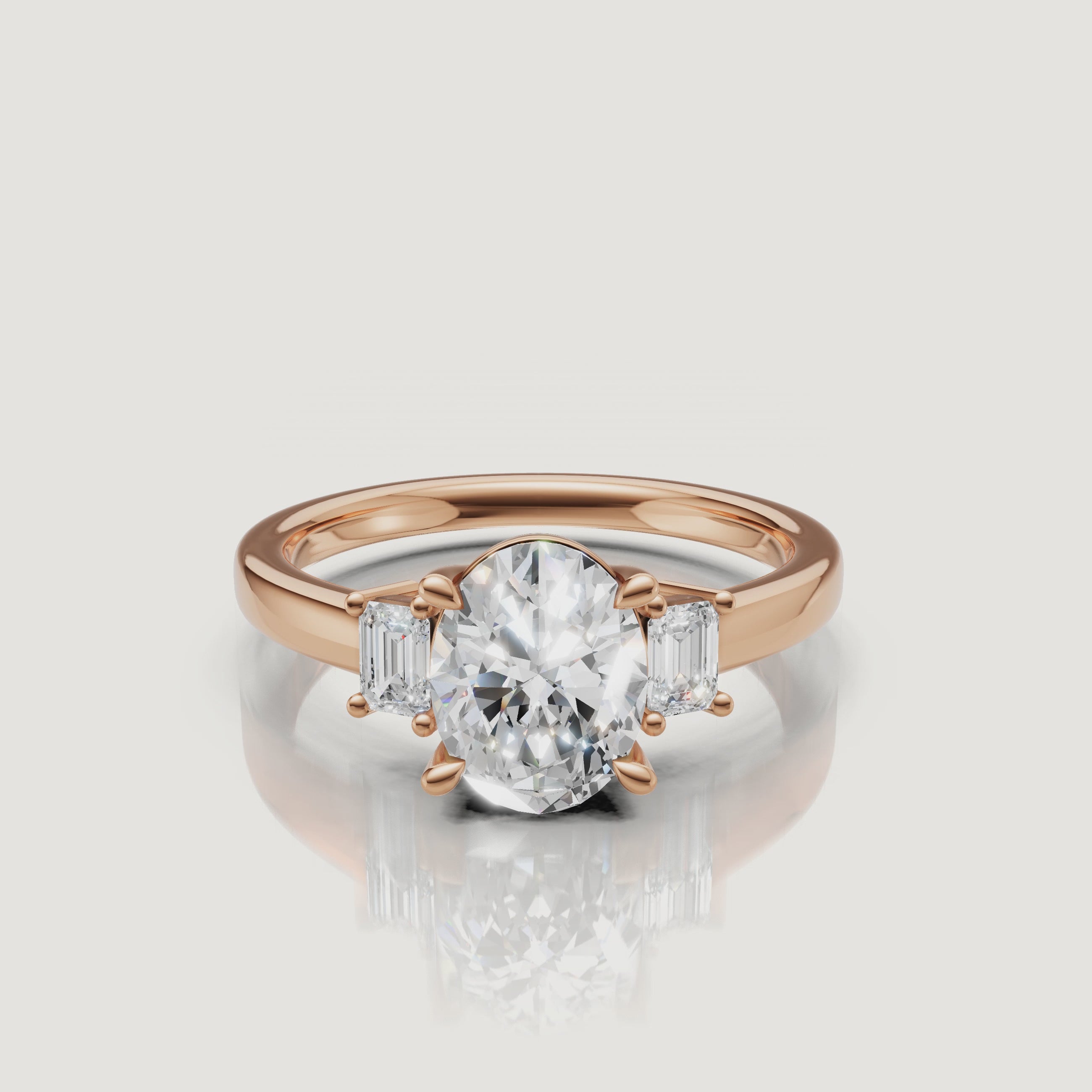 High-definition video rotation of a three-stone oval diamond ring in 18k rose gold, highlighting the warm metal tones and the clarity of the emerald-cut accent diamonds