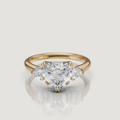 video of heart shaped lab grown diamond engagement ring with trillion side stones in 14k yellow gold