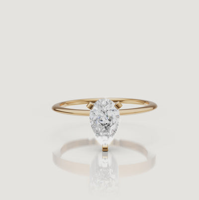 Cinematic video of a pear cut lab grown diamond solitaire engagement ring in yellow gold by Raul Diamonds featuring elegant hand movement, macro diamond sparkle, warm luxury lighting, and premium bridal jewelry styling