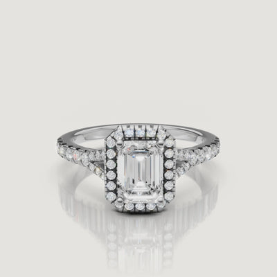 High-definition video of a white gold emerald cut diamond halo ring, demonstrating the hall-of-mirrors effect of the center stone and the brilliance of the side diamonds