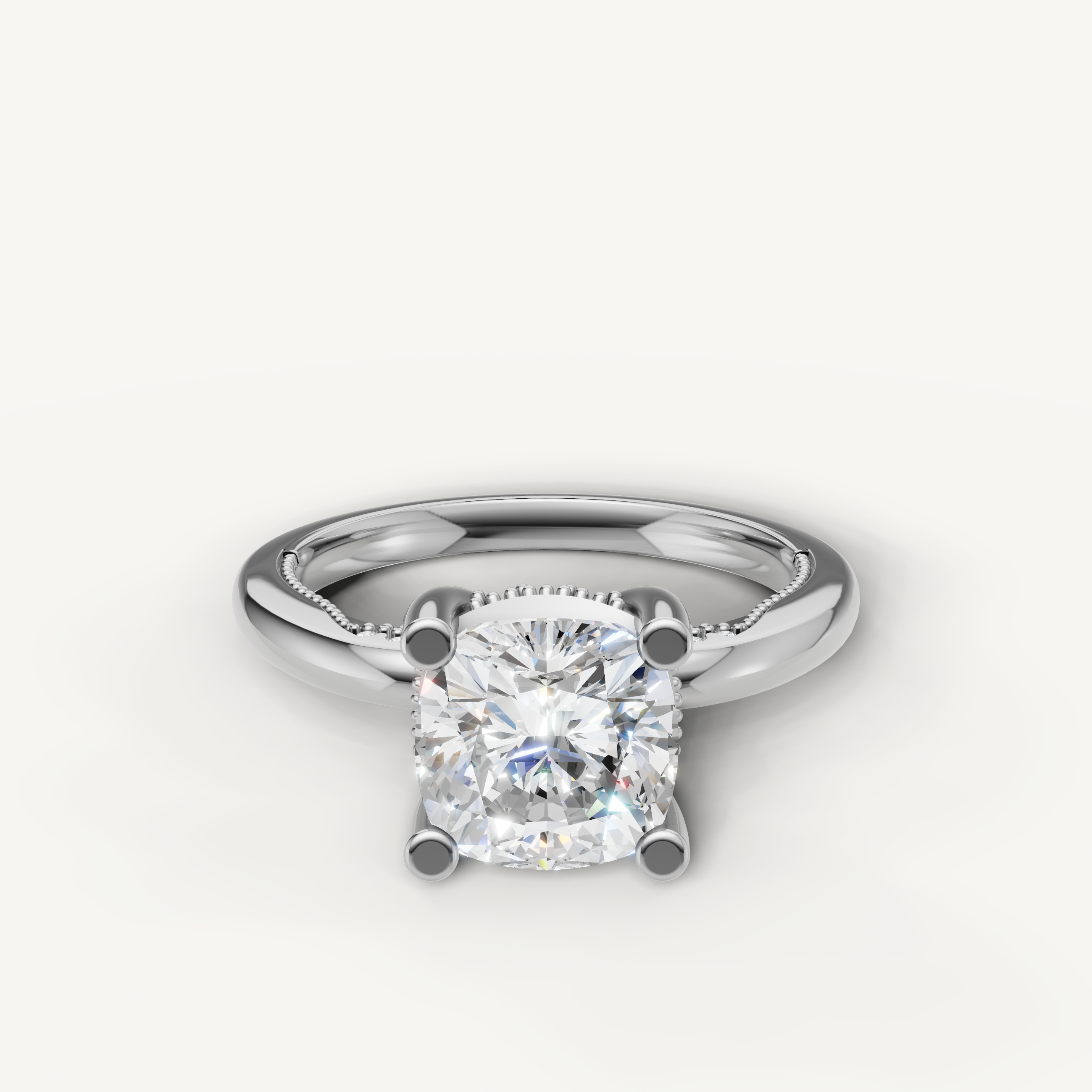 A timeless solitaire ring in polished white gold or platinum, featuring a brilliant cushion-cut diamond set in four prongs.