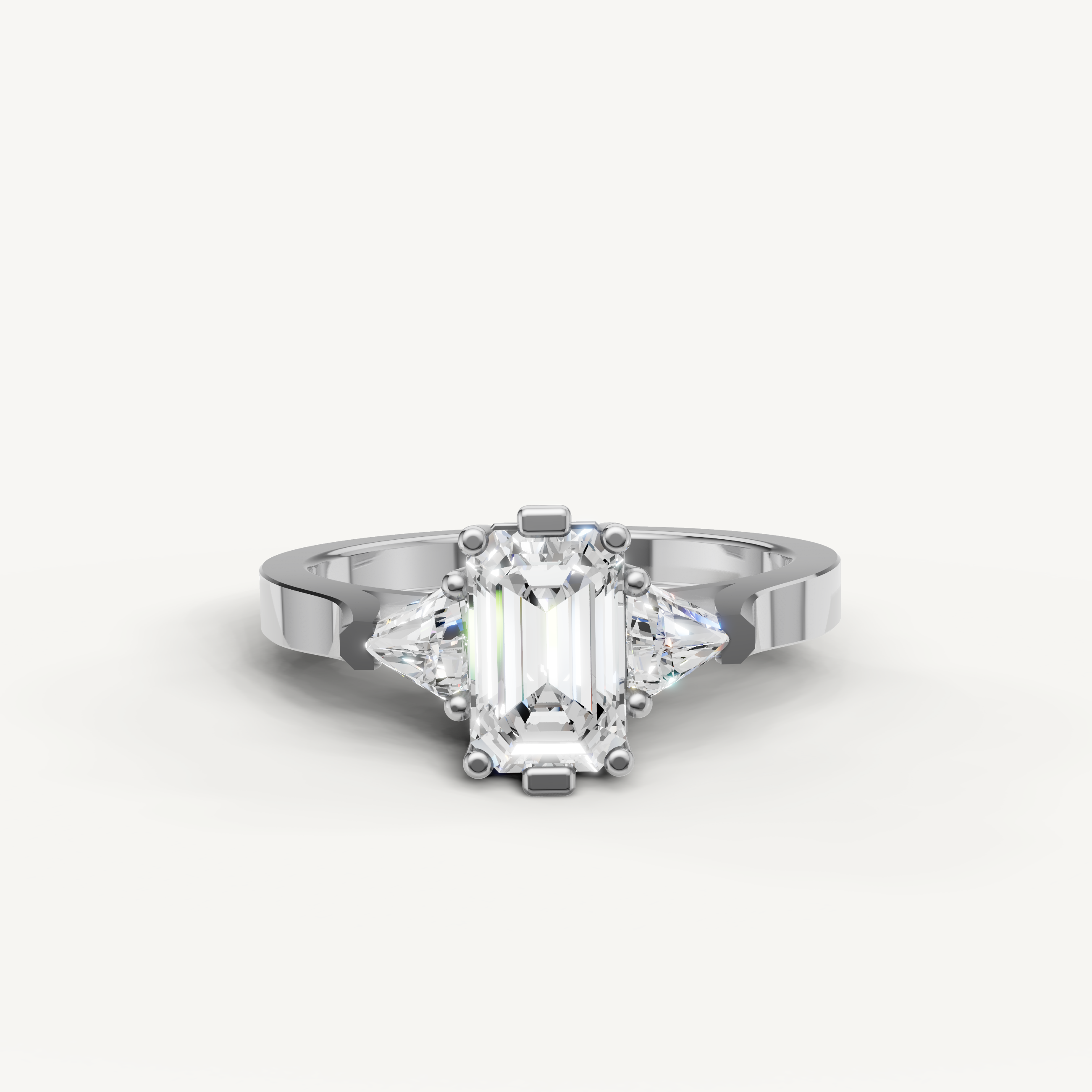 White gold emerald cut engagement ring with trapezoid side stones by Raul Diamonds.