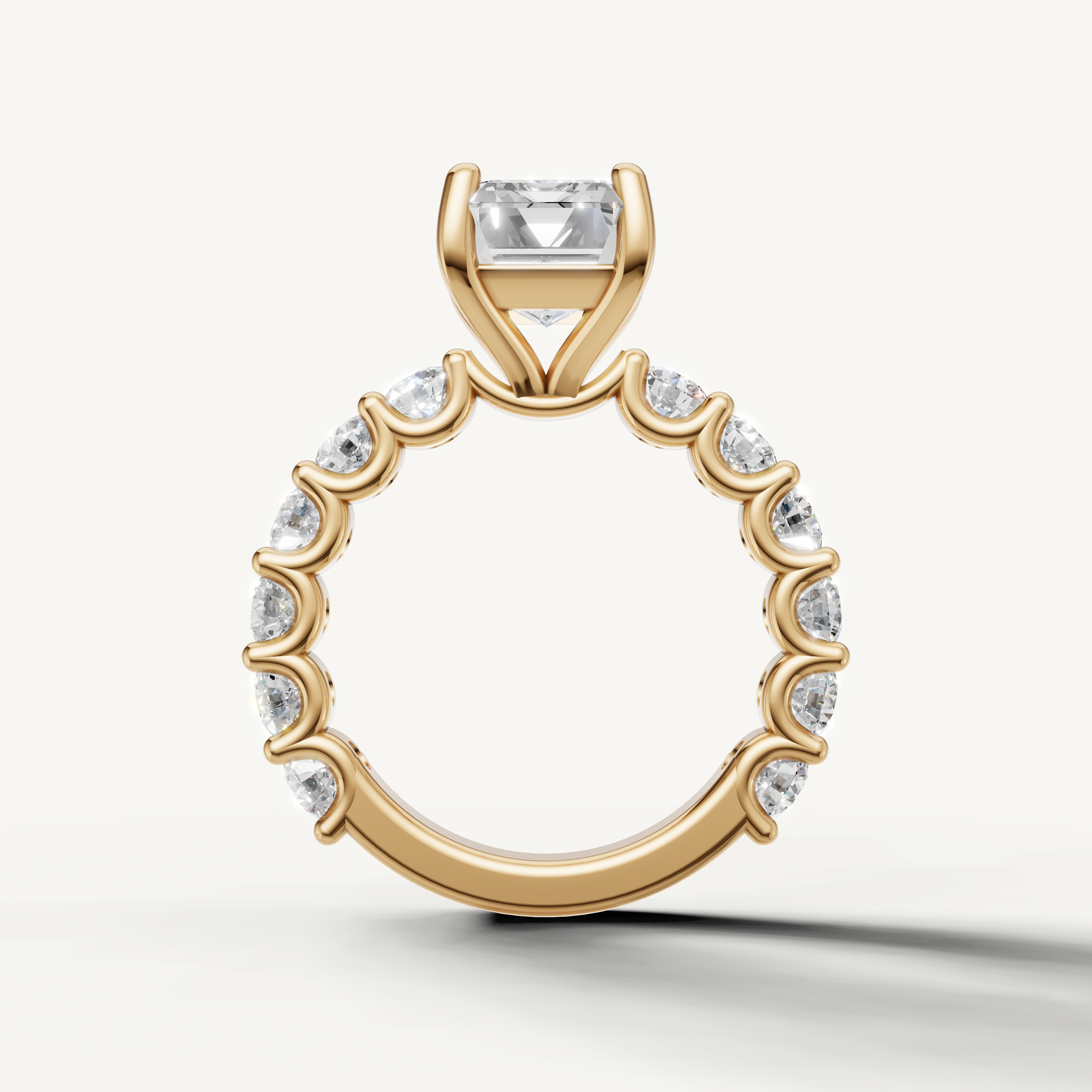 Elegant emerald cut engagement ring with open gallery and shared prong band yellow gold