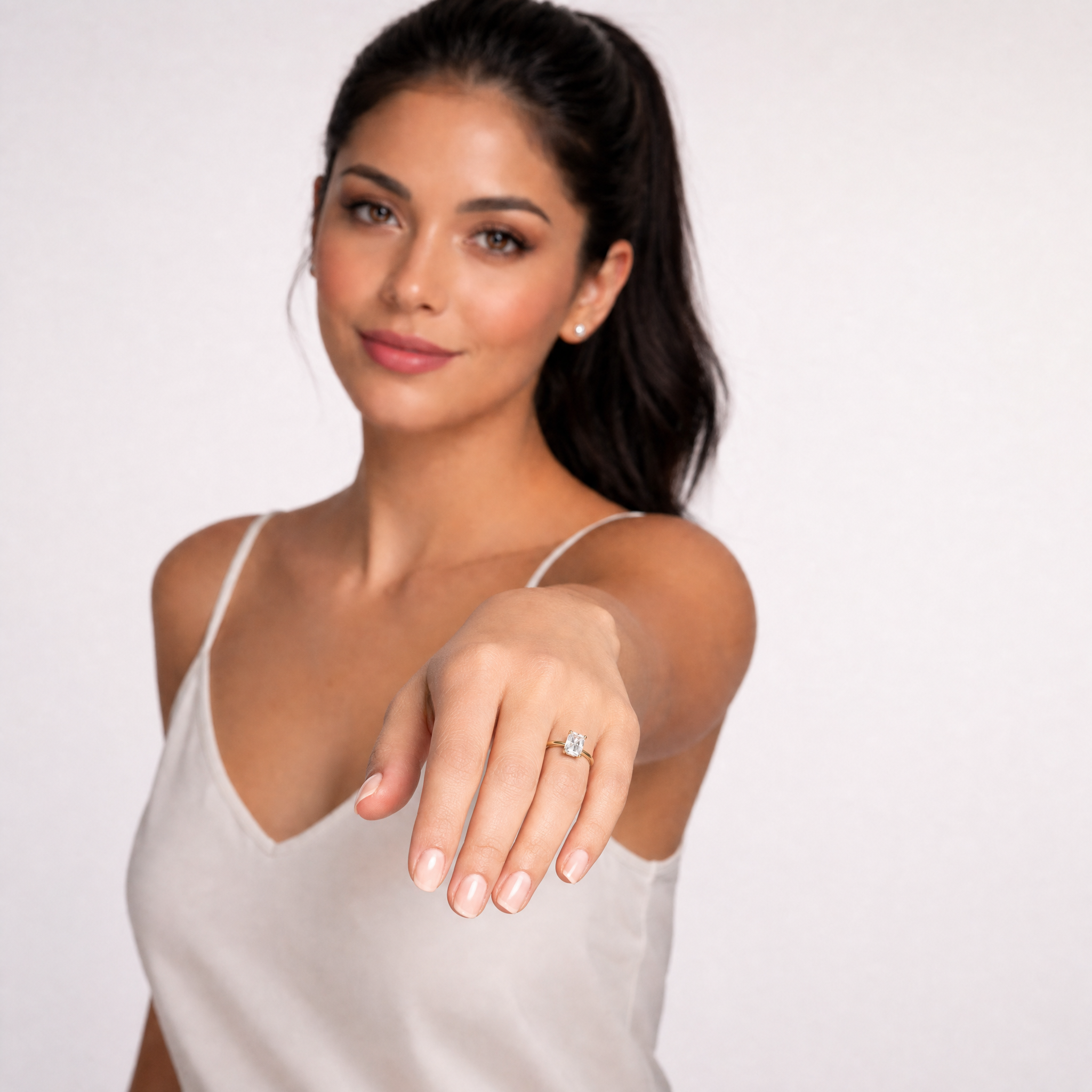 Sophisticated model Aura showcasing a Raul Diamonds radiant cut engagement ring, highlighting the crushed-ice sparkle and the elegant hidden halo collar detail